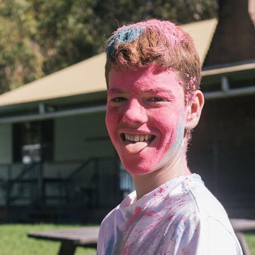 Teenage boy playing colour run in somersby